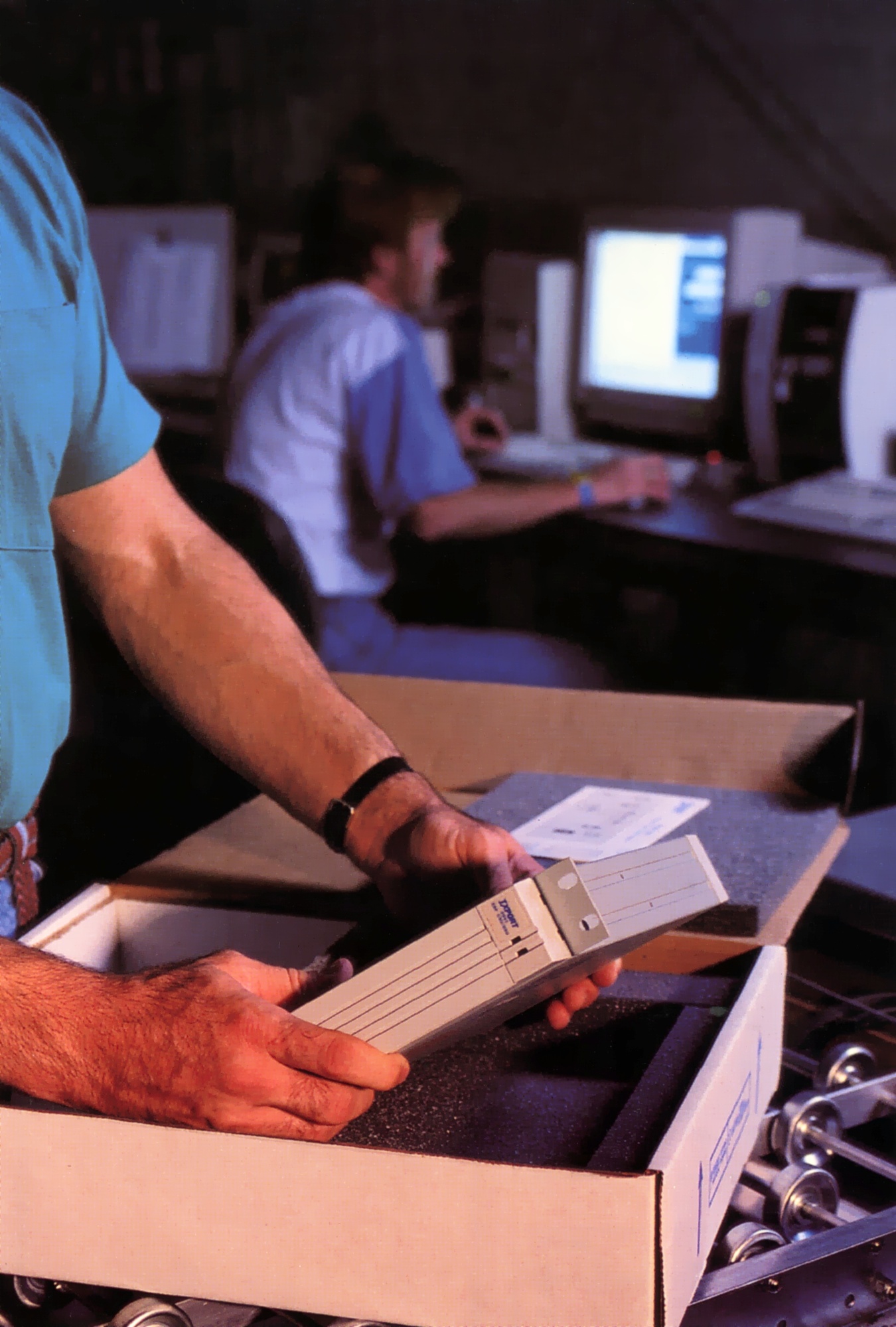 Man placing a product into its packaging on a roller conveyor